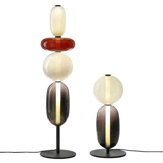 Two modern table lamps with colorful glass shades on a white background