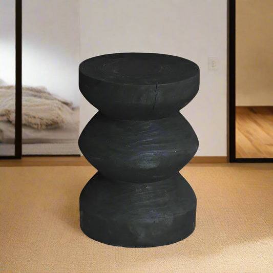 Black hand carved zig zag stool on a white background