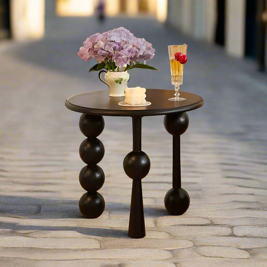 Small round table with decorative items on a stone pavement