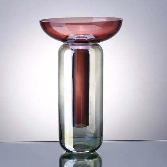 Glass vase with gradient color design on a reflective surface