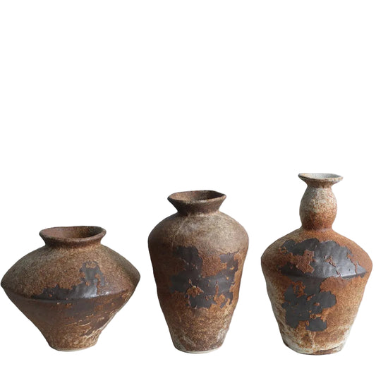 Three rustic ceramic vases of varying sizes on a light gray background