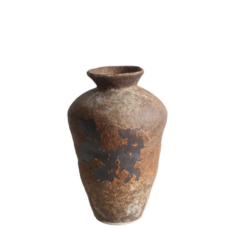 Brown ceramic vase with textured surface on a light gray background