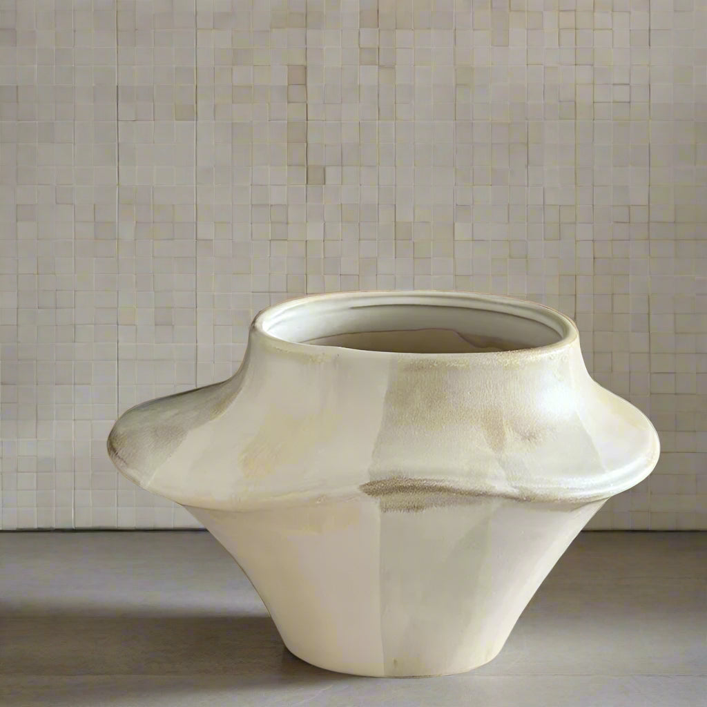 Beige ceramic vase with dimensions marked on a textured brown background