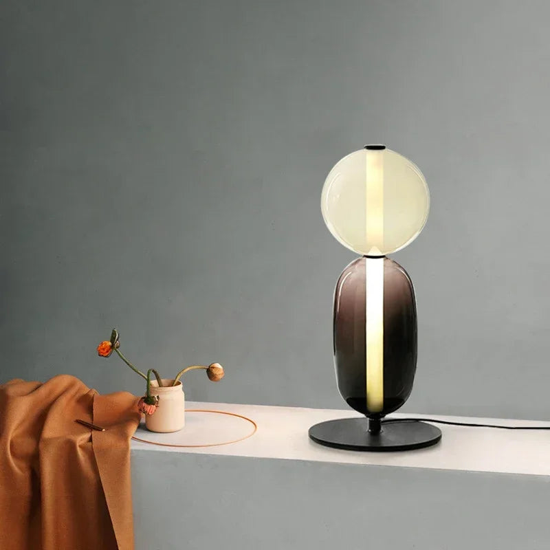 Modern table lamp with a glass shade on a gray surface with a dark gray background
