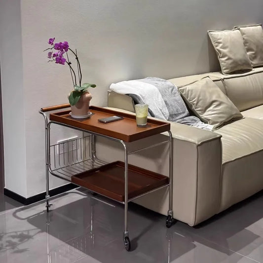 Beige sofa with a wooden side table holding a glass and a plant, in a modern living room setting.