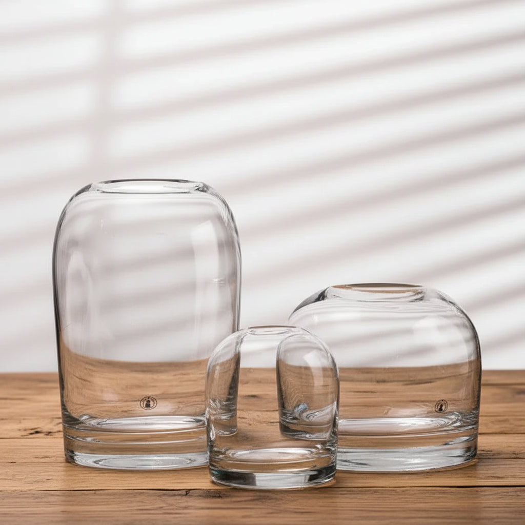 Three clear glass vases of different sizes on a light background
