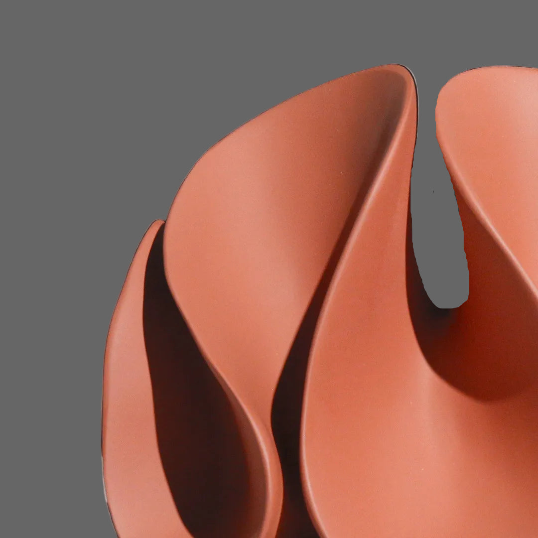 Close-up of a terracotta-colored ceramic bowl with a black background