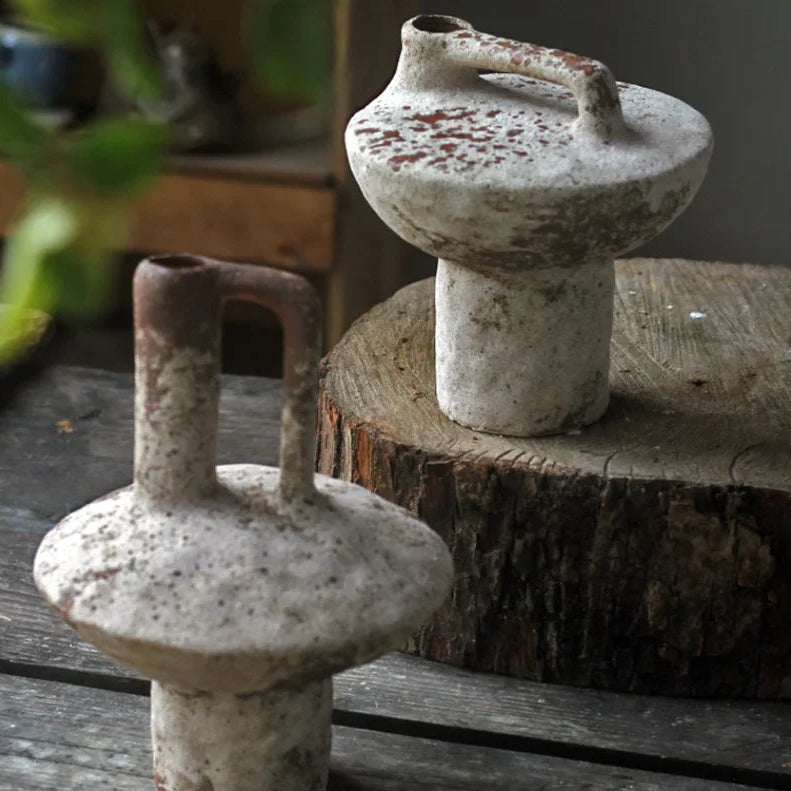 Two rustic ceramic pots on a wooden surface with a blurred background