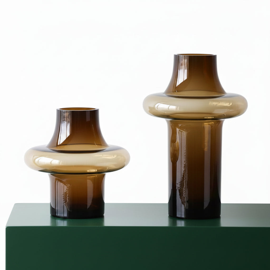 Two brown glass vases on a white surface with a neutral background