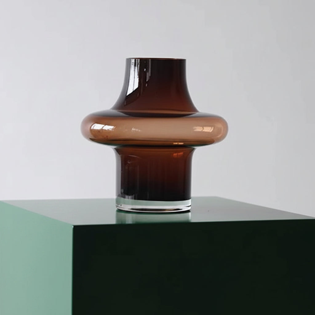 Brown glass vase on a white surface with a light gray background