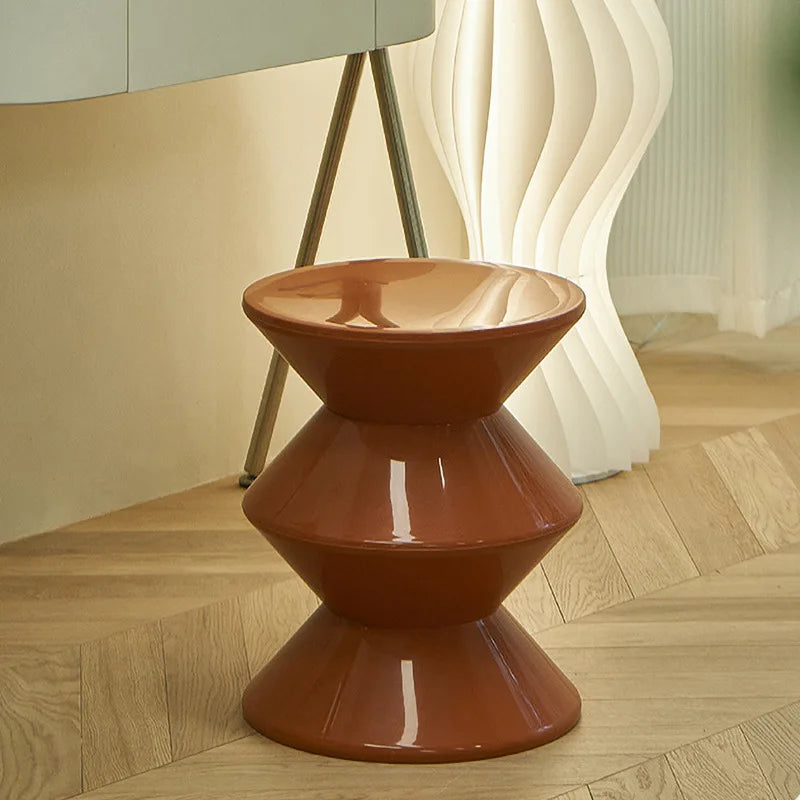 Brown geometric stool on a wooden floor with a blurred background
