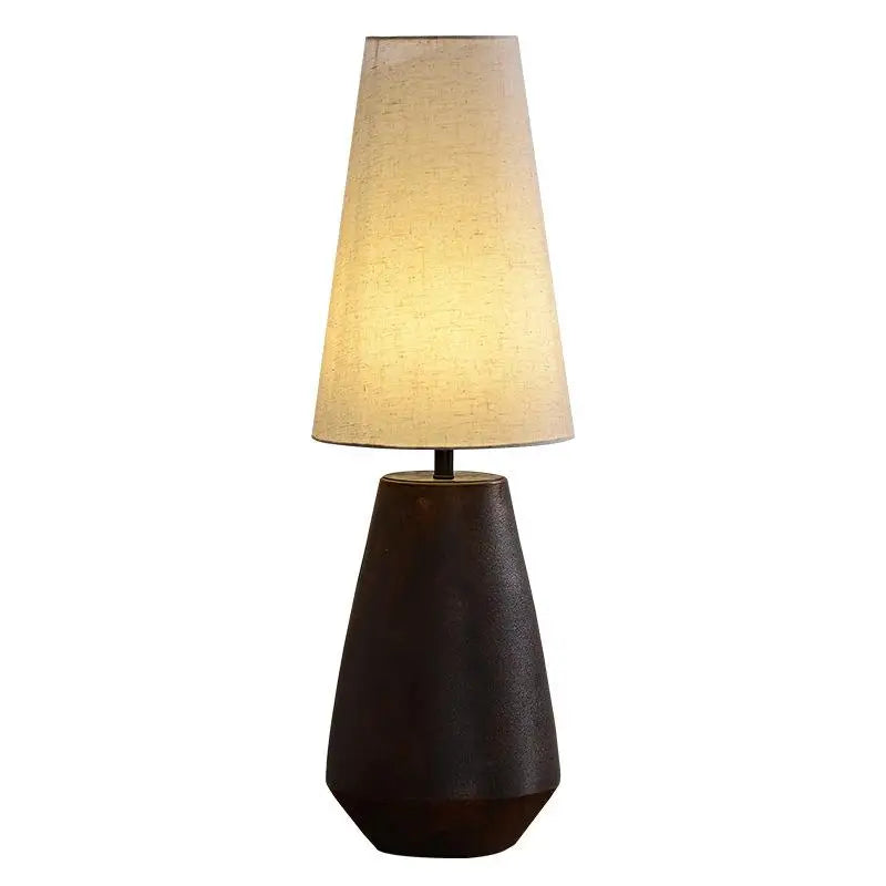 Table lamp with a brown base and beige shade on a white background