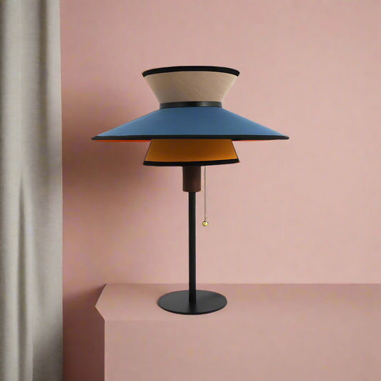 Modern table lamp with three-tiered shade on a white background