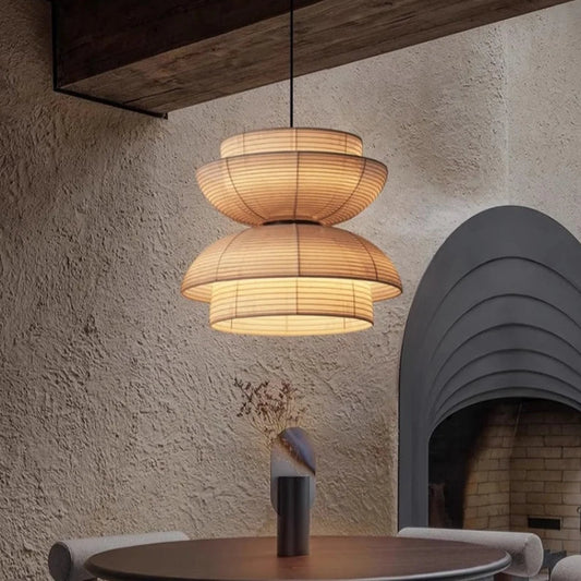 Modern pendant light hanging in a room with a textured wall and fireplace.